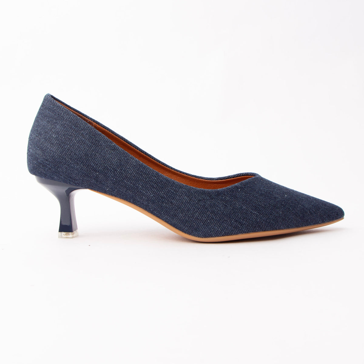 Navy blue denim kitten heels for women, an indigo denim pointed court with the woven twill grain showing across the vamp, on a glossy navy kitten heel tipped with a clear block over a natural tan sole edge