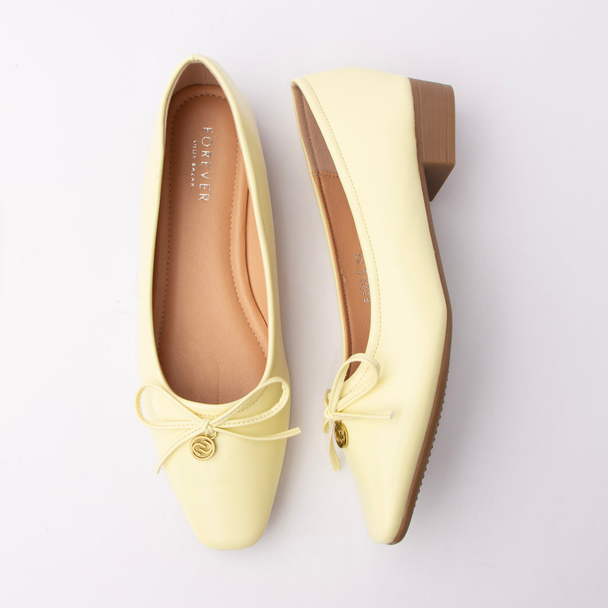 Yellow pumps for women, both shoes laid flat