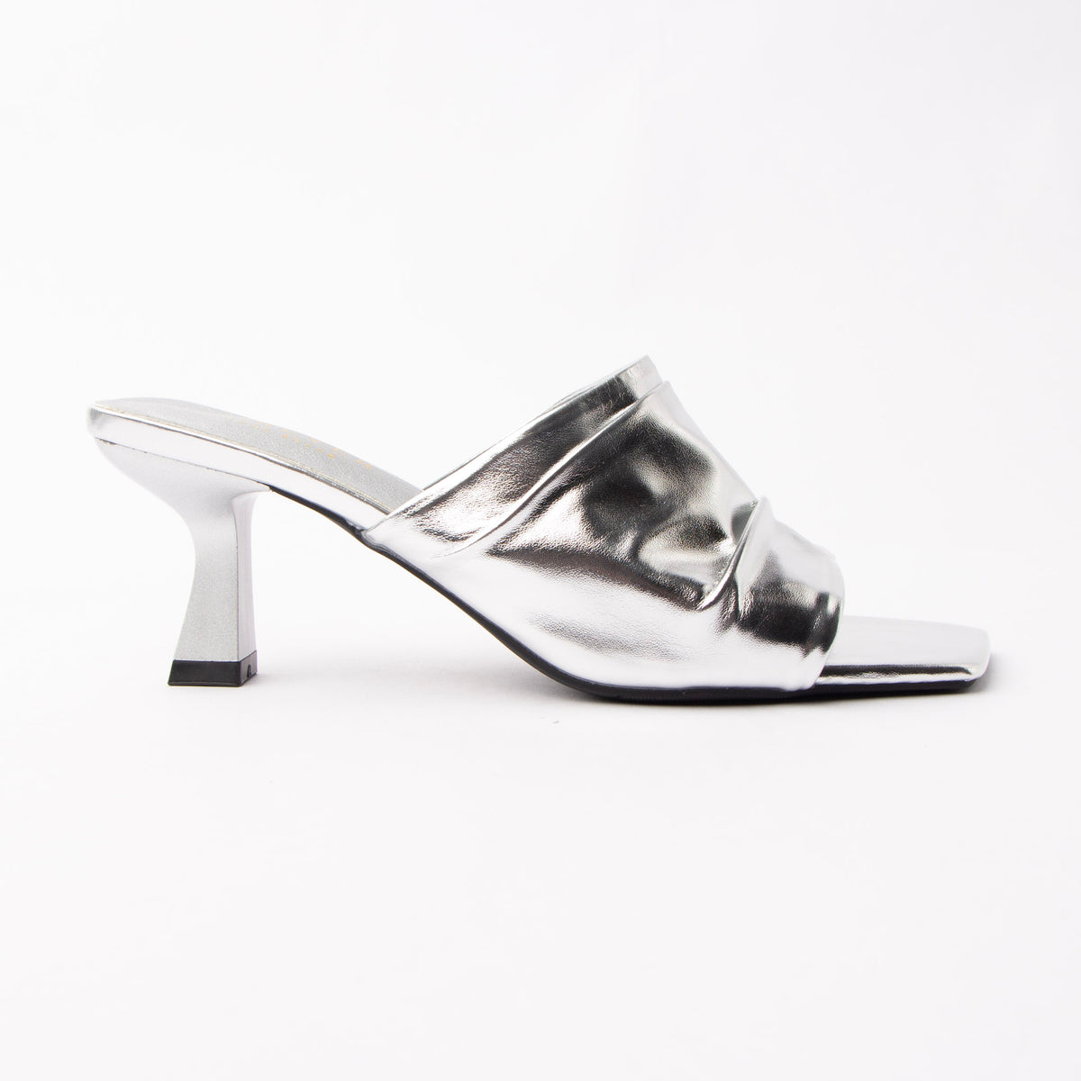 Silver metallic mules for women, one wide panel of mirror-foiled silver leather gathered across the instep and caught underneath by a slim piped strap over the toes, open through the arch and heel, on a slim flared spool heel in matching chrome-bright foil