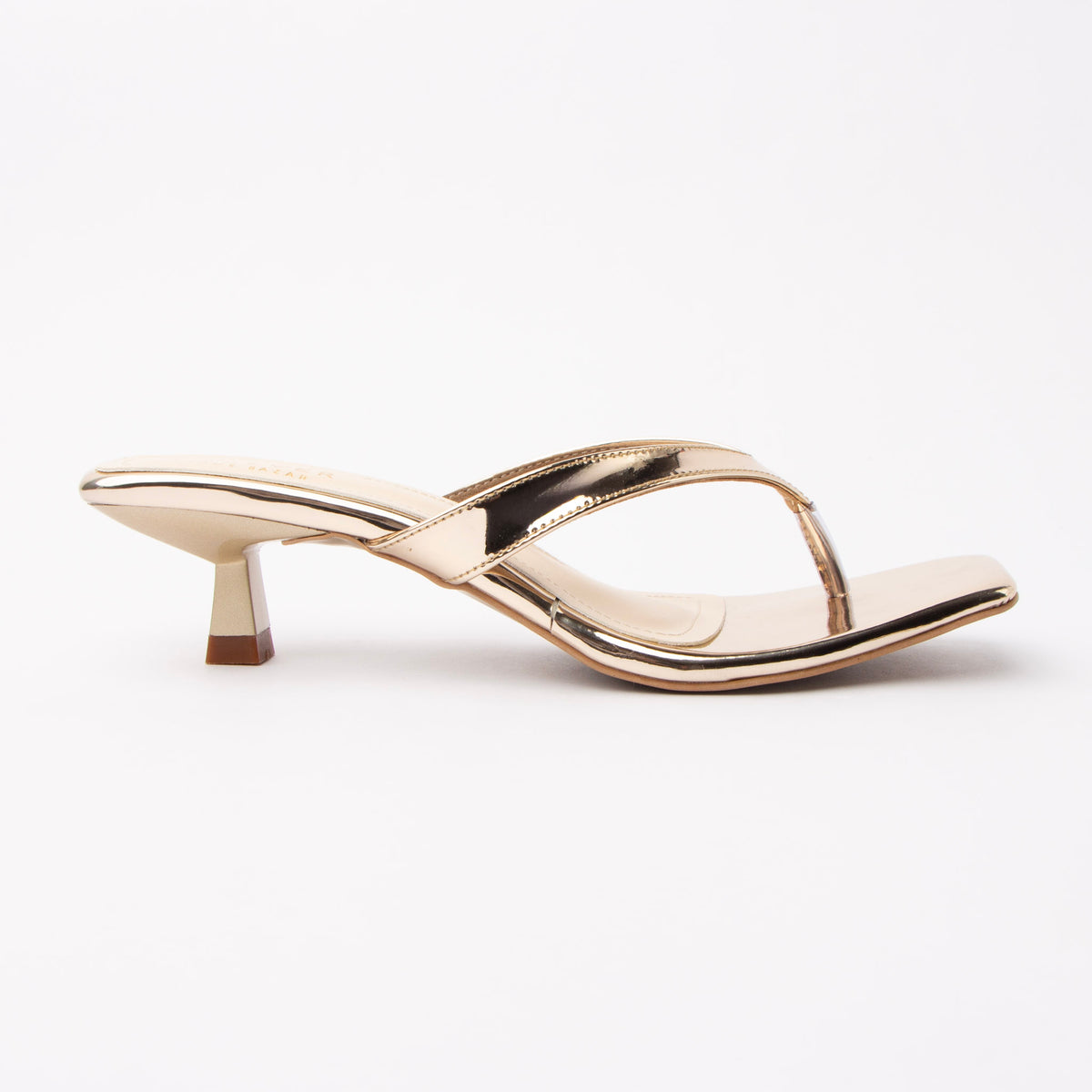 Gold toe-post kitten heel mules for women, side view of the twisted vamp band, squared-off open toe and slim kitten heel