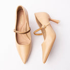 Beige mary jane pumps for women, a single tonal beige ribbed instep strap fastens through a small gold oval buckle across a nude padded footbed, above a sharply pointed toe and a flared spool heel finished with a clear resin tip
