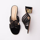 Black block heel mules for women, a butterfly-shaped cut-out vamp built from bead-studded straps over sheer mesh, a nude cushioned footbed stamped in gold, and a suede-finish block heel banded with a mirror-gold plate