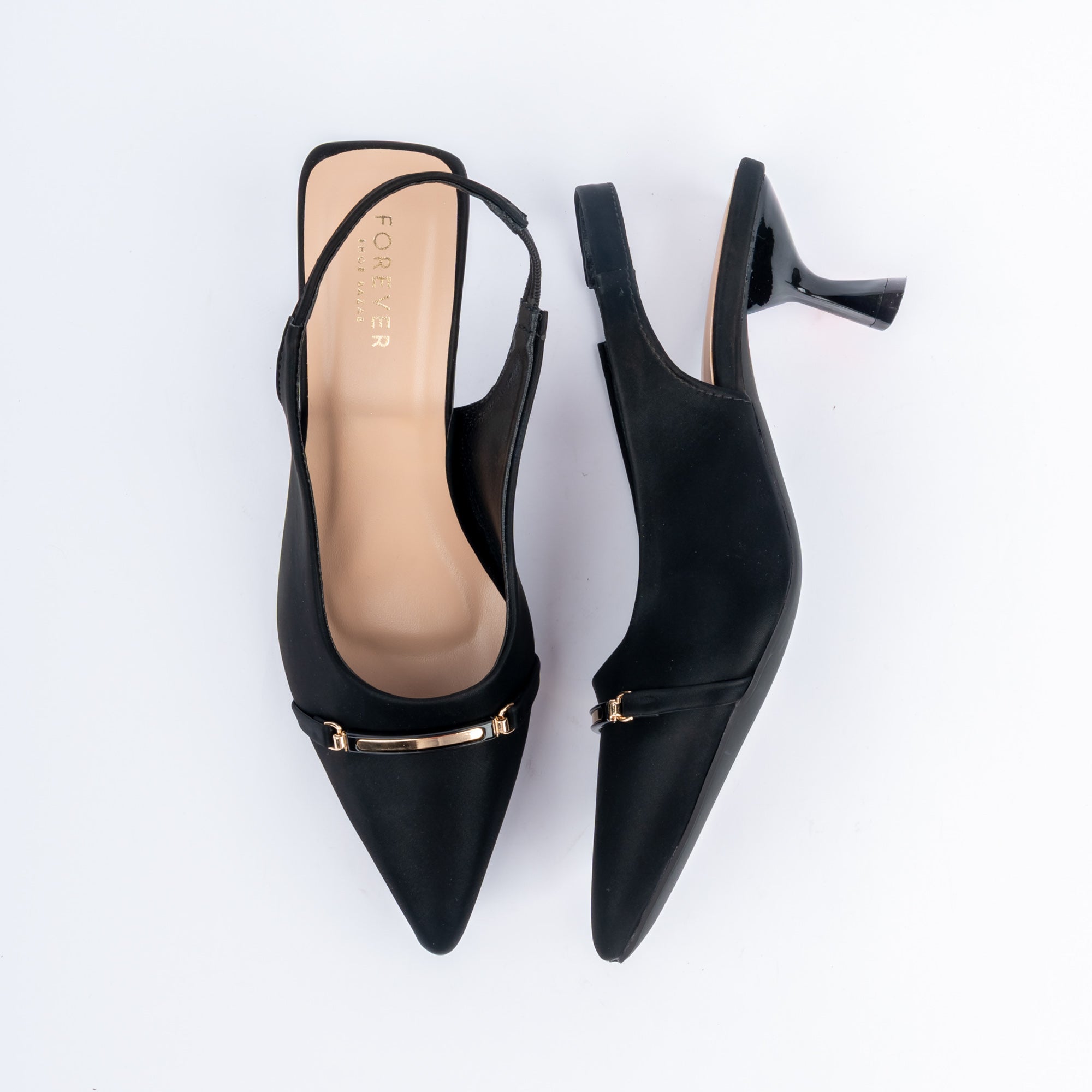 Black pumps for women, a slim gold horsebit bar laid flat across the vamp, a narrow slingback strap and a polished flared spool heel above a nude footbed