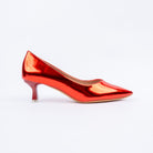 Red pumps for women, an unbroken mirror-finish patent upper drawn to a sharp elongated point, a low-cut topline and a glossy flared spool heel