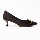 Black buckle kitten heels for women, a sharply pointed matte black court with a low plain instep and a waved topline, crossed by a slim self-colour band caught in a gold pin buckle, on a low flared kitten heel in glossy black patent