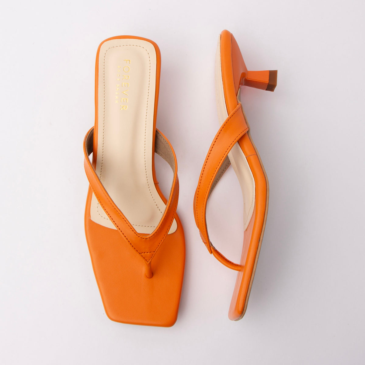 Orange toe-post kitten heel mules for women, both shoes laid flat