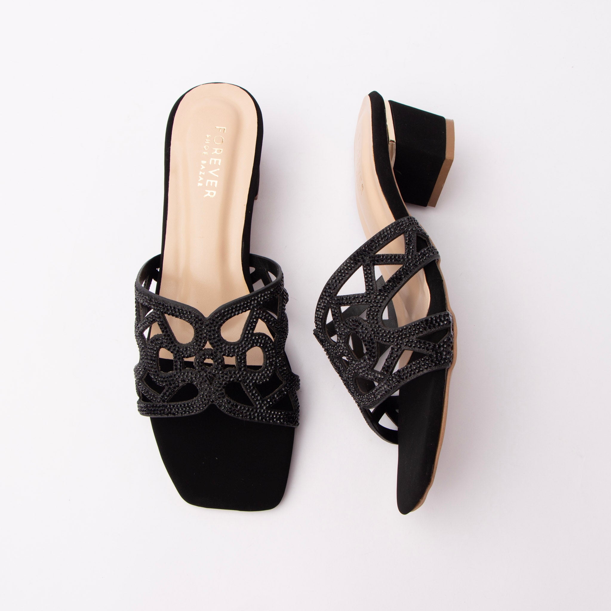 Black cut out block heel mules for women, one wide scalloped vamp band in black laser-cut pu, every cutout edge outlined in fine jet-black micro-crystals so the sparkle reads tonal rather than contrasting, set over a nude-lined cushioned footbed with a gold heel-seat logo, plain open back and a squat black-covered block heel