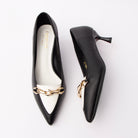 Black chain link pumps for women, a gold faceted chain-link plate is set across an ivory vamp band that runs into a matching ivory toe panel on a black upper, with a black-lacquered flared spool kitten heel, a black sole edge and a white padded footbed