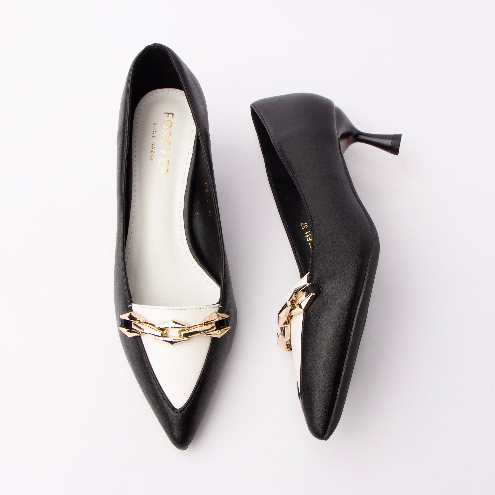 Black chain link pumps for women, a gold faceted chain-link plate is set across an ivory vamp band that runs into a matching ivory toe panel on a black upper, with a black-lacquered flared spool kitten heel, a black sole edge and a white padded footbed