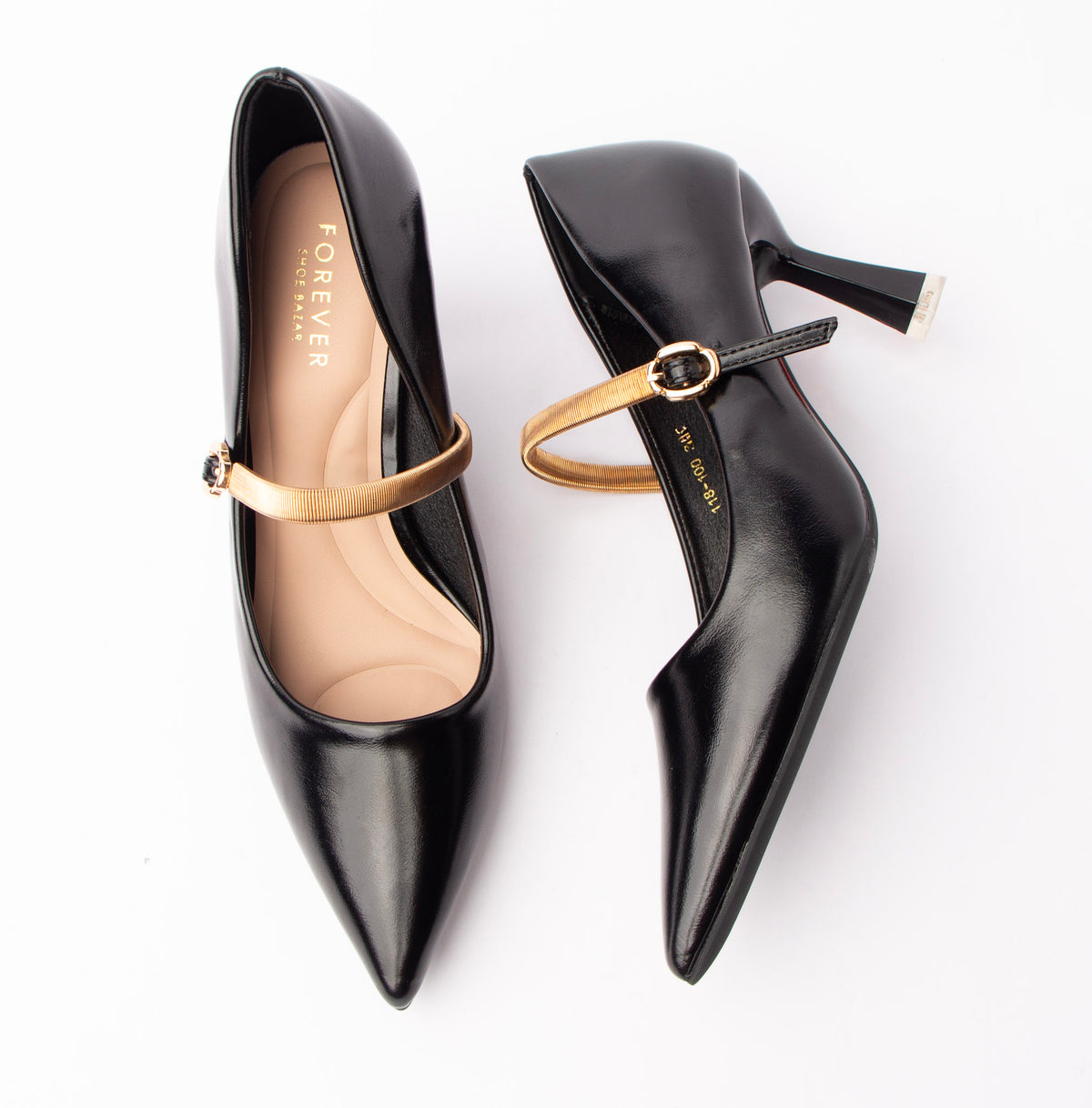 Black mary jane pumps for women, a slim gold metallic ribbed instep strap crosses the vamp into a matching gold oval buckle, set against a high-shine black pointed-toe upper with a nude padded footbed and a flared spool heel capped in silver