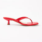 Red toe-post kitten heel mules for women, side view of the twisted vamp band, squared-off open toe and slim kitten heel