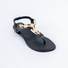 Black flat sandals styled for party wear