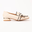 Beige piped block heel loafers for women, a bright ivory block-heel loafer outlined throughout in fine black piping, with a knotted ivory vamp strap held by a flat gold oval buckle and a squared heel plated in gold
