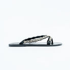 Black flat sandals for women, a double-row V-strap pairing a scalloped black jelly bead edge with a graduated line of round clear crystals, on a high-gloss moulded black footbed
