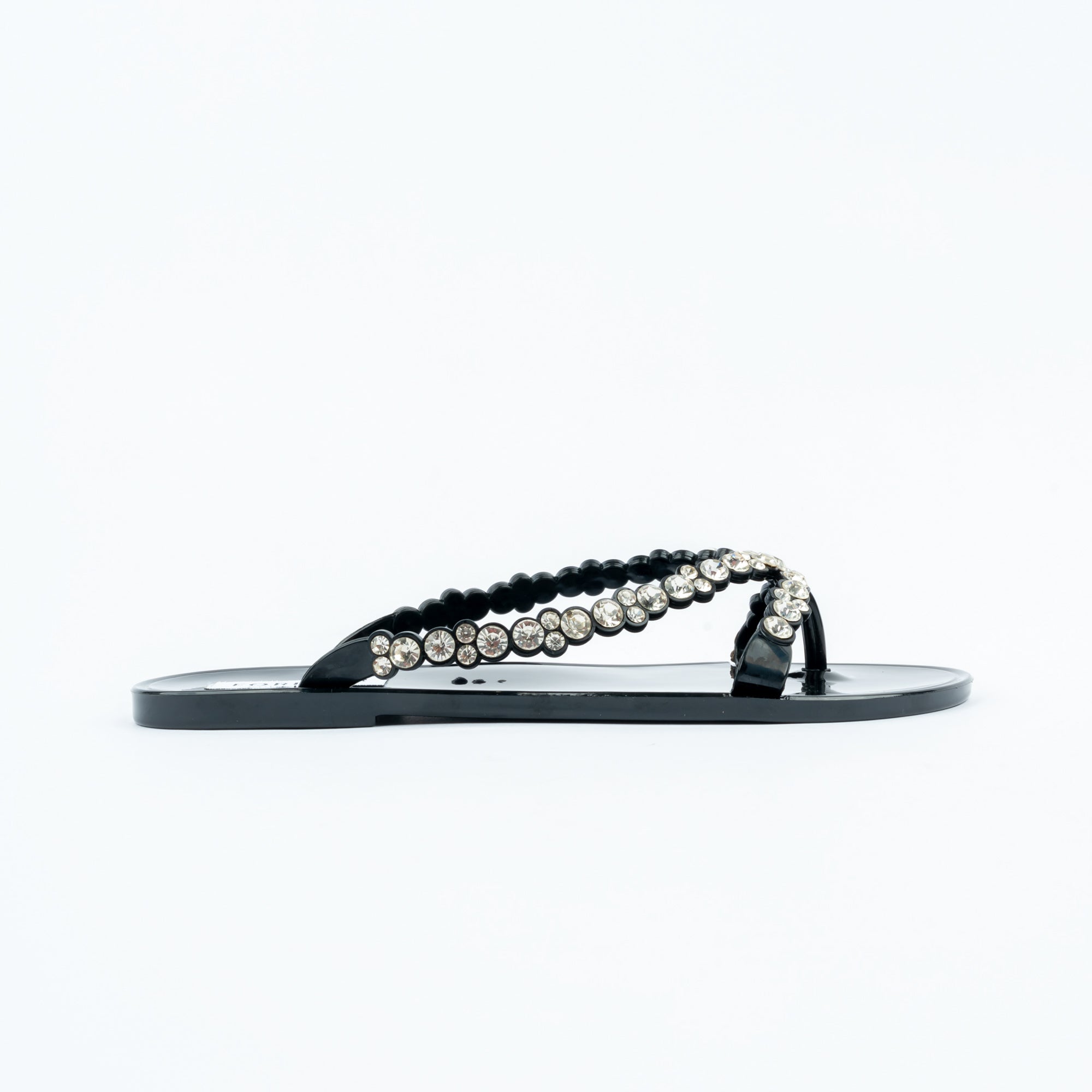 Black flat sandals for women, a double-row V-strap pairing a scalloped black jelly bead edge with a graduated line of round clear crystals, on a high-gloss moulded black footbed