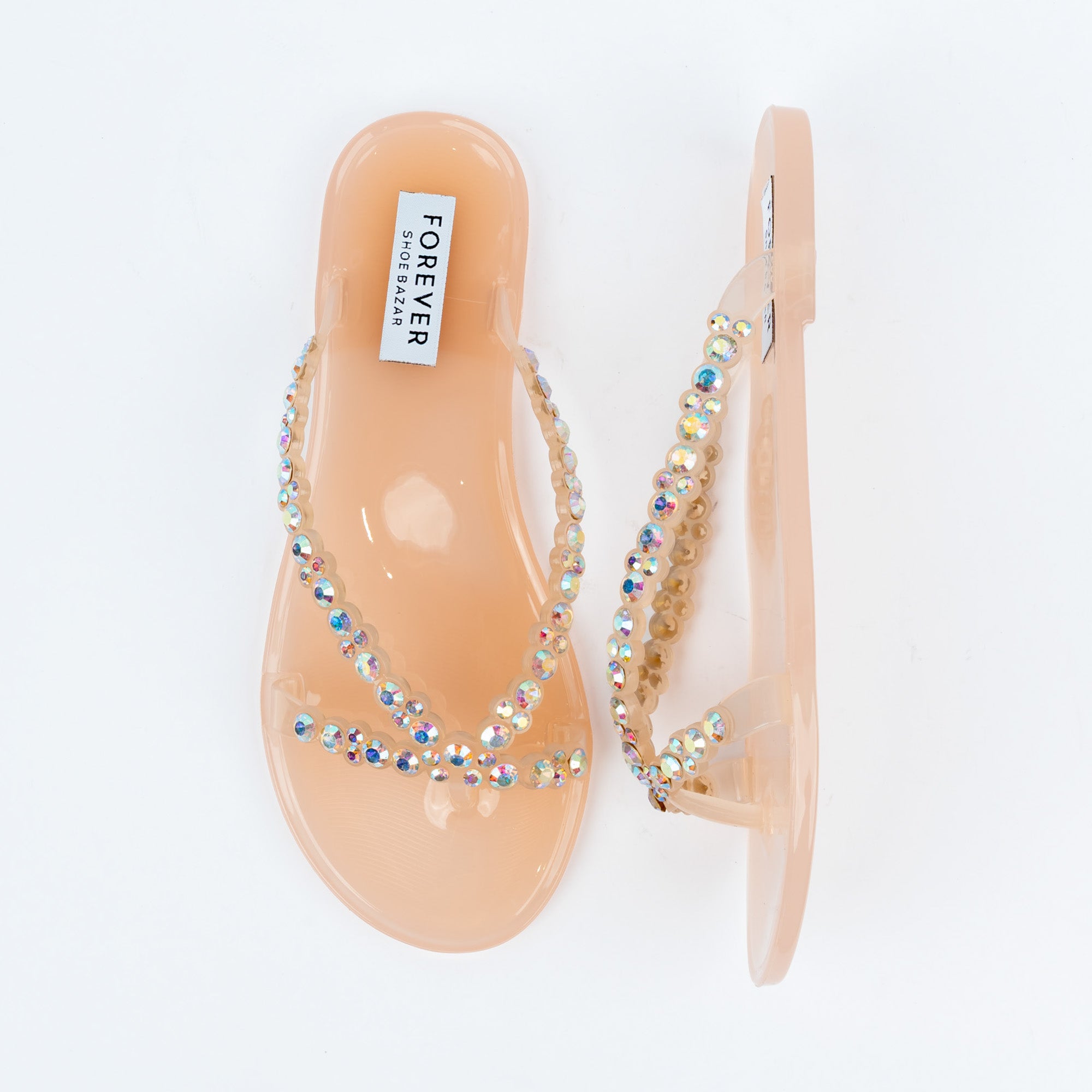 Beige flat sandals for women, translucent nude jelly V-straps set with rows of iridescent round crystals running down to a slim toe post, on a moulded jelly footbed