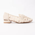 Beige lace loafers for women, ivory floral guipure lace embroidered onto sheer mesh so the daisy motifs sit against a see-through ground, banded across the vamp with smooth pale leather, on a low block heel ringed in gold over a tan-camel footbed