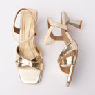Gold kitten heel sandals for women, snake-embossed metallic straps crossing over the vamp, an elasticated ankle loop, and a squared-off sole edge on a flared hourglass heel