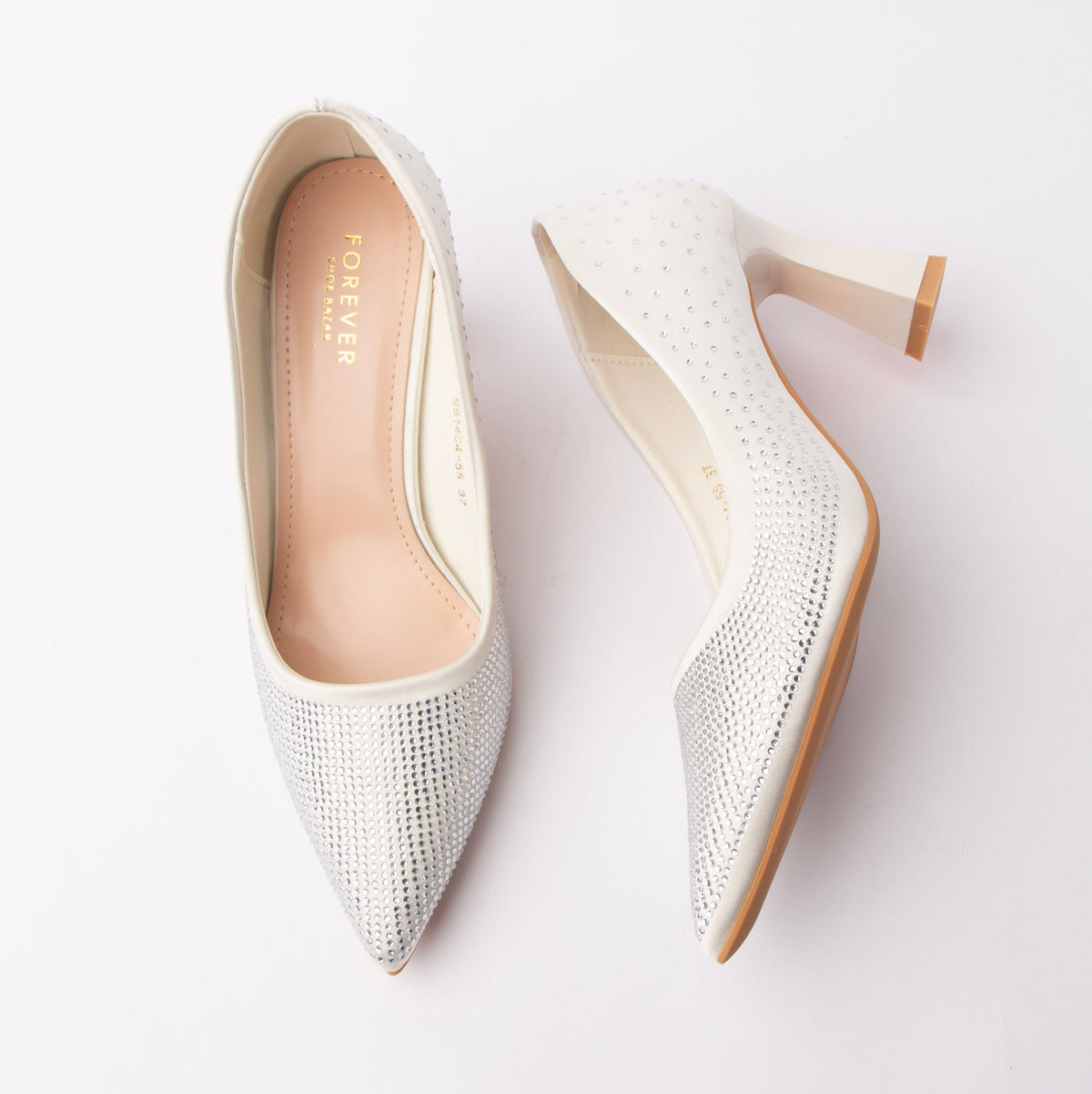 White rhinestone block heel pumps for women, ivory satin is paved with clear silver-toned crystals over the pointed toe that scatter loosely towards the heel counter, with a dipped topline, a flared ivory block heel and a blush cushioned footbed