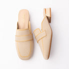 Beige knit loafer mules for women, a beige knitted-mesh loafer mule with a tonal elasticated saddle band laid over a knit-in apron outline, a squared toe and a low block heel capped with a gold metal trim above a nude padded footbed