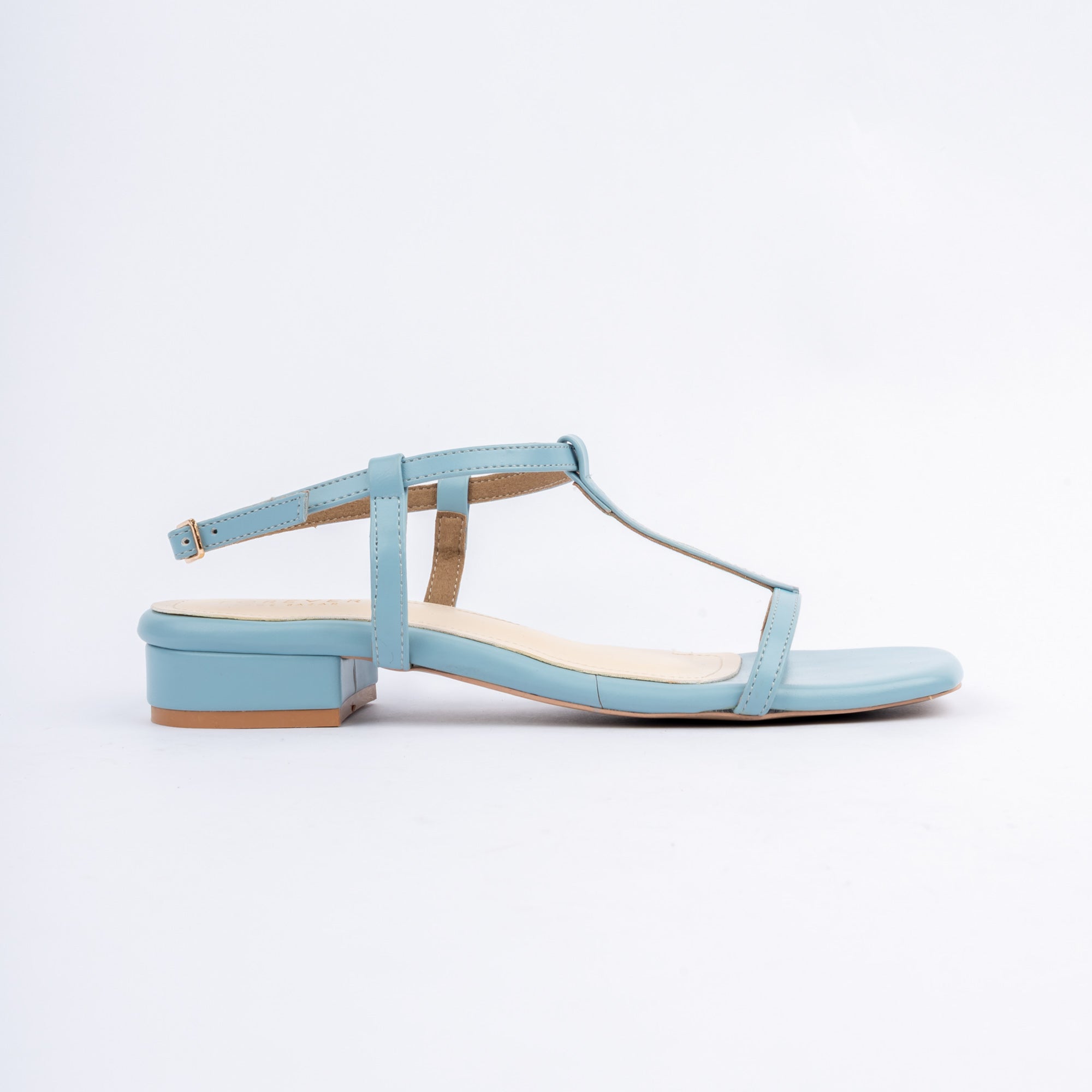 Blue block heel sandals for women, a clean T-strap of narrow bands joining a toe band to a centre stem and a full ankle loop fastened by a small gold pin buckle, on a cream contrast footbed and a squared-off low block heel