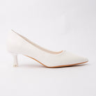 White pointed kitten heels for women, a bright optic-white pebble-grain court with a sharply pointed toe, on a matching white kitten heel finished with a small clear block over a natural tan sole edge