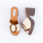 Beige platform heel mules for women, a tortoiseshell ring laid across a basket-woven band