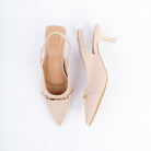Cream pumps for women, a slim gold metal bar riding a thin strap across the pointed vamp, with a stretch slingback strap above a flared kitten heel with a clear tip