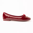 Maroon patent ballerina flats for women, a deep wine-red patent ballerina lifting to cherry along the toe, gathered red binding running around the topline and heel counter, with a fine cord bow tipped in gold