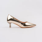 Gold pumps for women, an unbroken mirror-finish metallic upper with a low V-cut topline and a flared spool kitten heel tipped with a clear translucent block