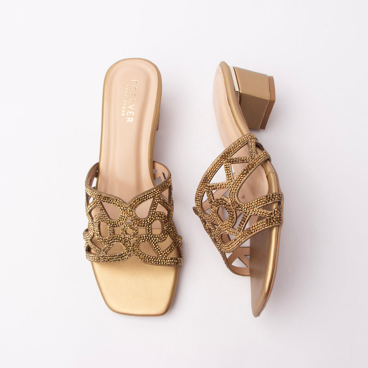 Copper cut out block heel mules for women, a deep antique-copper metallic upper carrying a looped cut-out vamp studded with darker bronze stones for a burnished, almost oxidised sparkle against a blush-nude footbed, on a copper-covered squared block heel with an open back