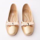 Gold bow ballerina flats styled for everyday wear