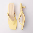 Yellow toe-post kitten heel mules for women, both shoes laid flat