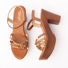 Brown block heel sandals for women, gold pyramid and dome studs scattered across three croc-embossed crossover straps, an elasticated ankle loop, and a wood-grain platform and block heel