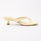 Yellow toe-post kitten heel mules for women, side view of the twisted vamp band, squared-off open toe and slim kitten heel